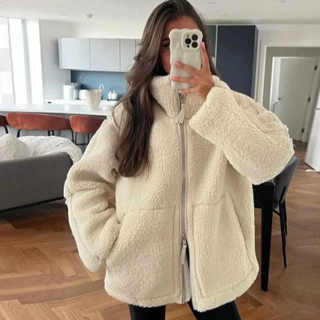 Spiegelaufnahme einer frau, die eine beige lammwolljacke trägt