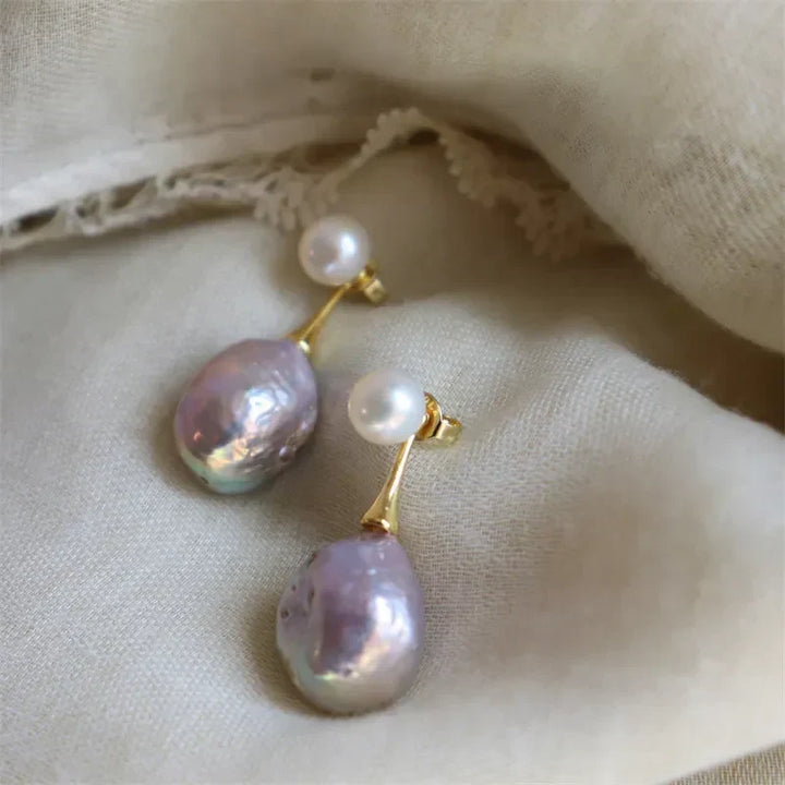 Elegant gold-colored earrings with lilac pearl